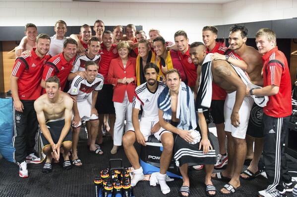 Angela Merkel dans le vestiaire des joueurs après leur victoire contre le Portugal   en prenant la pose (Coupe du Monde 2014)