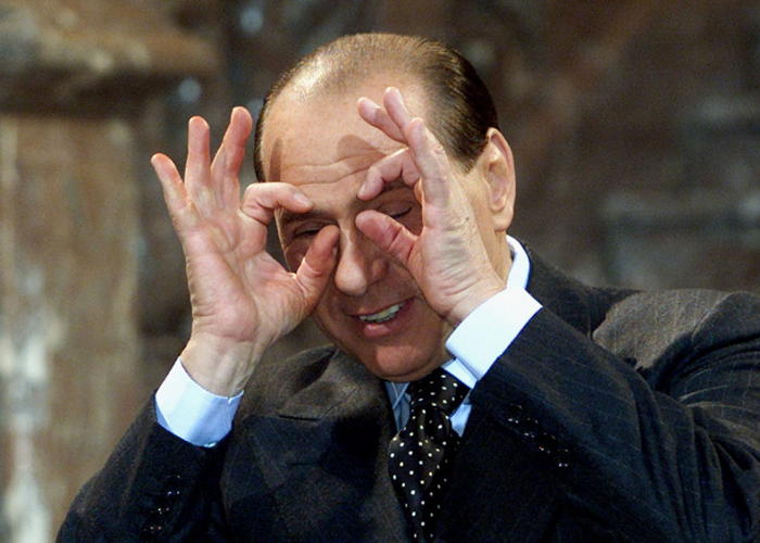 Silvio Berlusconi imite les photographes lors d’un sommet de l’UE à Bruxelles, le 14 décembre 2001.