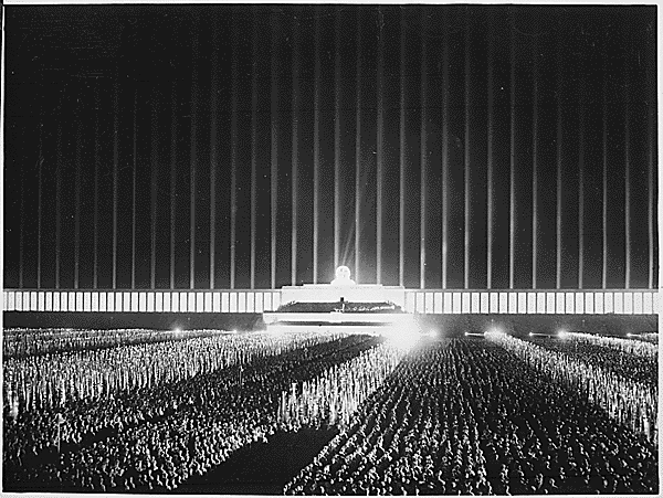 Procession nocturne de SS à Nuremberg avec des torches,   encadrés de 150 projecteurs de la DCA manipulés par des soldats   afin de constituer une cathédrale de lumière. 