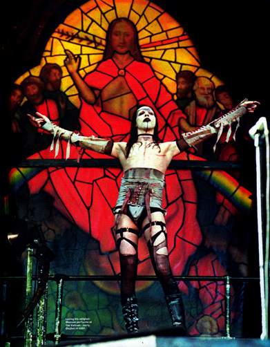 Marilyn Manson avec un vitrail représentant le Christ en arrière plan pendant un concert