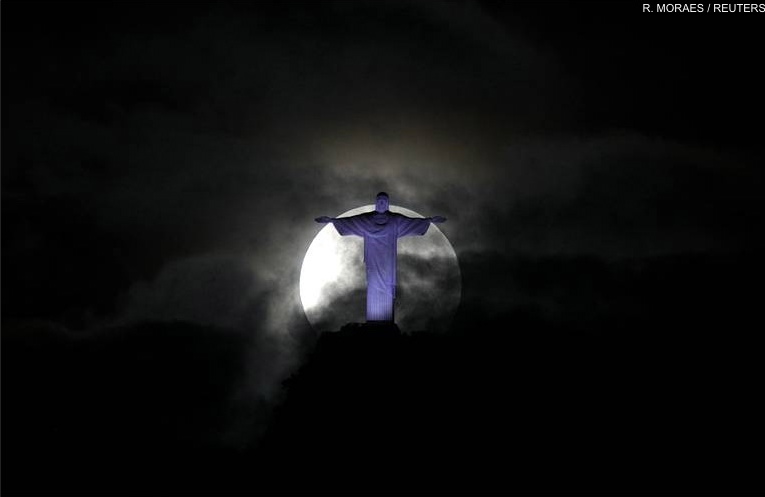 Silhouette de la statue du Christ Rédempteur sur fond de pleine lune